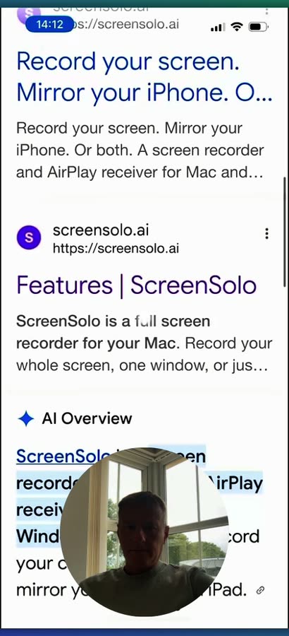 An iPhone mirrored onto the computer, scrolling a page of search results.